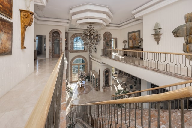 interior space featuring a notable chandelier, crown molding, a towering ceiling, and tile patterned floors