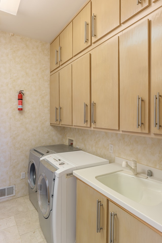 washroom featuring light tile patterned floors, sink, cabinets, tile walls, and washer and dryer