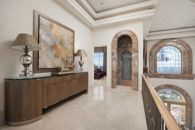 hall featuring light tile patterned floors, a wealth of natural light, and a tray ceiling