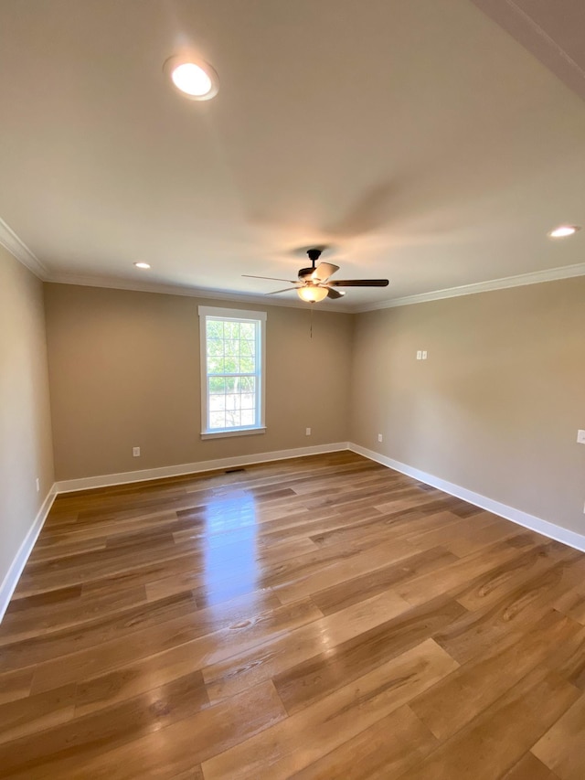 unfurnished room featuring ornamental molding, wood finished floors, and baseboards