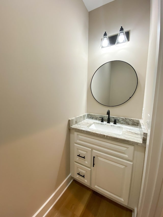 bathroom with vanity, baseboards, and wood finished floors