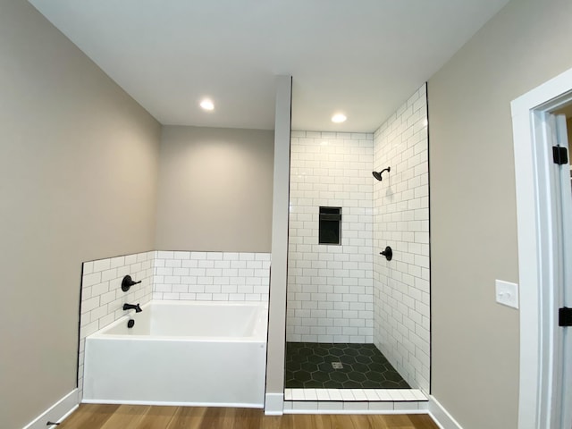 full bath with a garden tub, a shower stall, baseboards, and wood finished floors