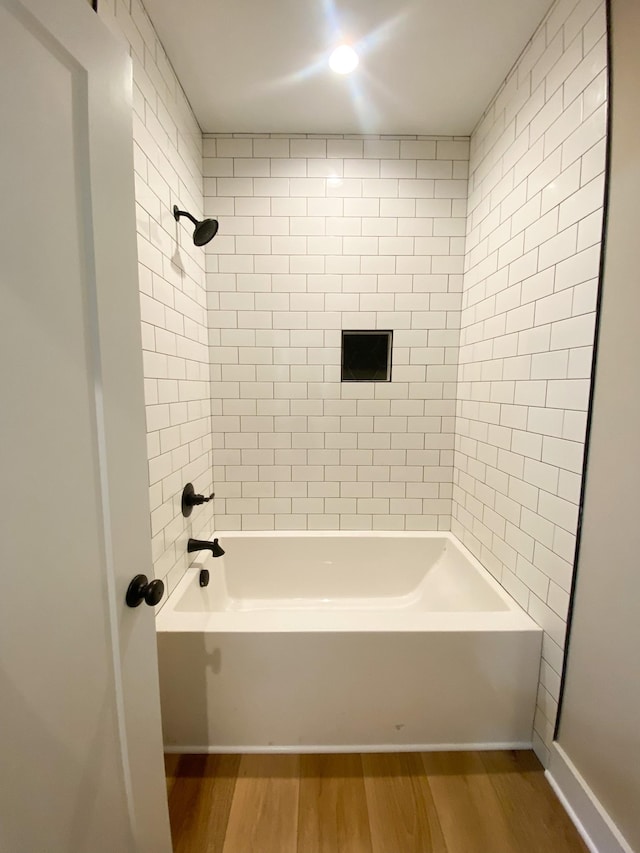 bathroom with shower / bath combination and wood finished floors