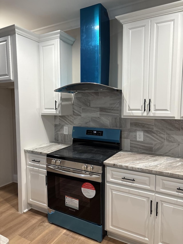 kitchen with white cabinetry, wall chimney range hood, light stone countertops, tasteful backsplash, and stainless steel range with electric stovetop