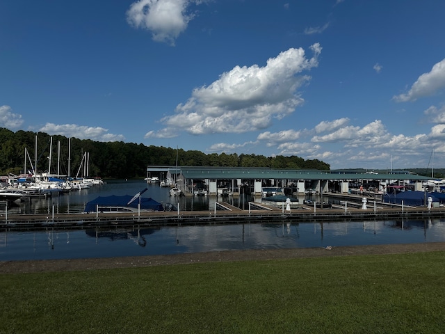 view of dock with a water view and a yard