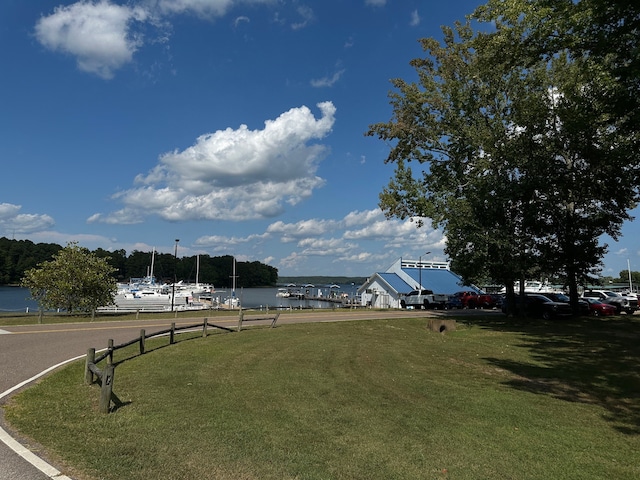 view of property's community with a water view and a yard