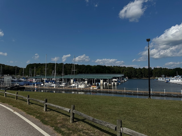 dock area with a lawn and a water view