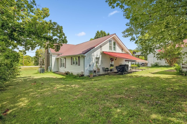 view of property exterior featuring metal roof, central AC unit, and a lawn