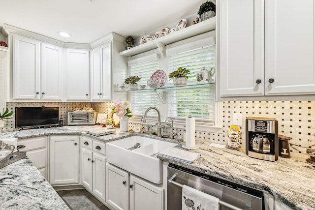 kitchen with dishwasher, backsplash, a sink, and white cabinets