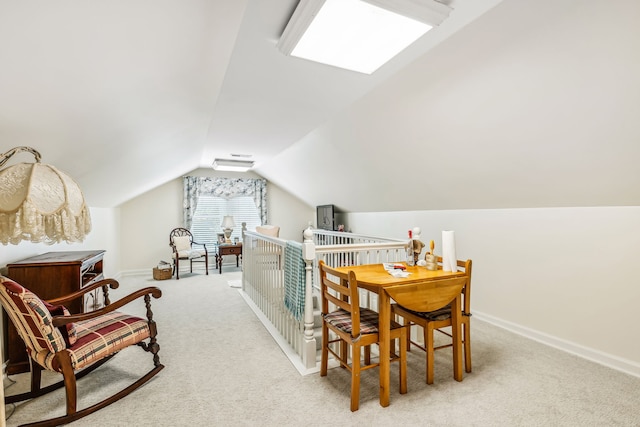 interior space with light carpet and vaulted ceiling with skylight