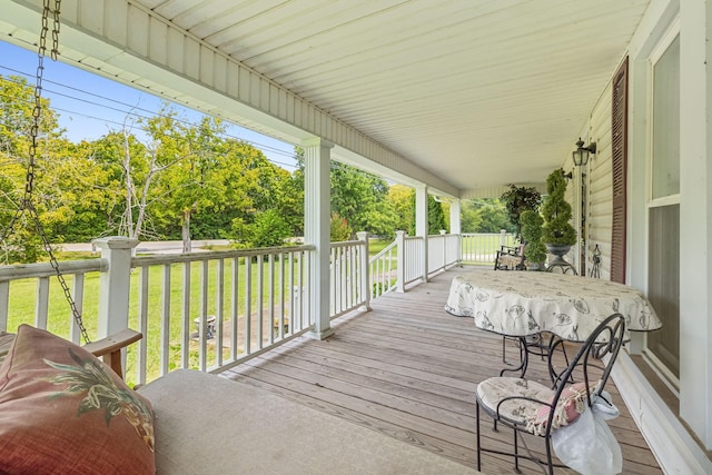 deck with a porch and a yard