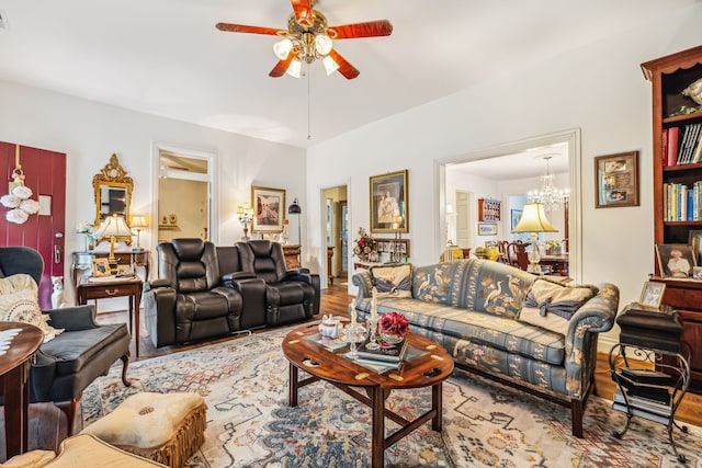 living room featuring light wood-type flooring and ceiling fan with notable chandelier