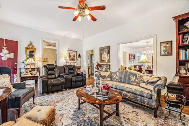 living area featuring light wood-type flooring, visible vents, and ceiling fan with notable chandelier