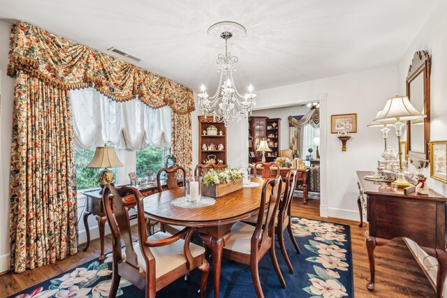 dining area featuring an inviting chandelier and hardwood / wood-style flooring