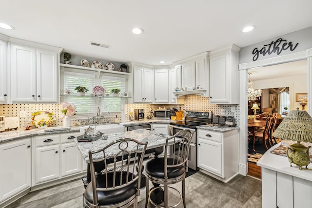 kitchen featuring white cabinets, tile patterned flooring, appliances with stainless steel finishes, and light stone counters