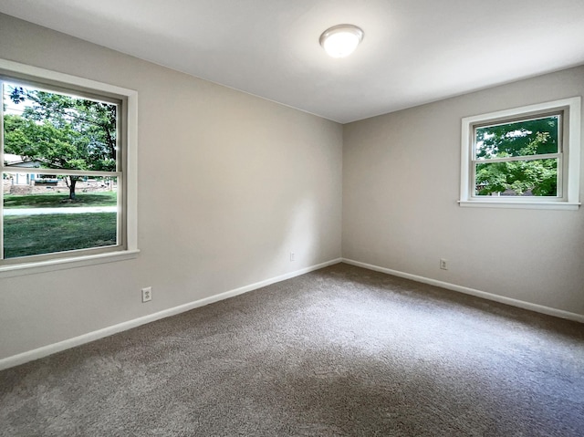 carpeted empty room featuring baseboards