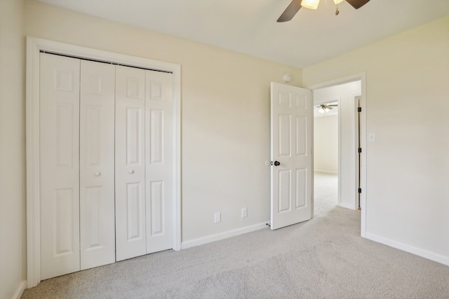 unfurnished bedroom with ceiling fan, light colored carpet, and a closet