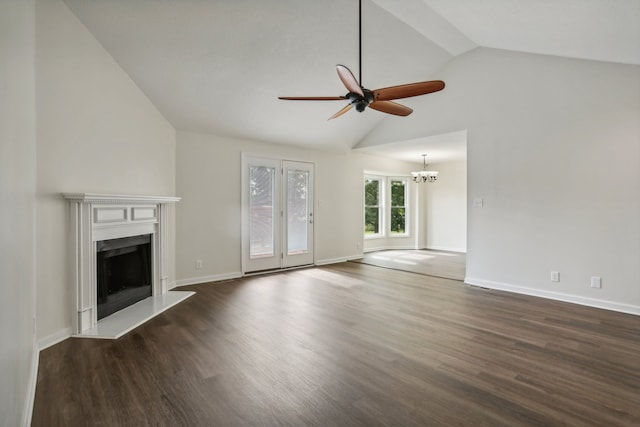 unfurnished living room with high vaulted ceiling, ceiling fan with notable chandelier, and dark hardwood / wood-style flooring