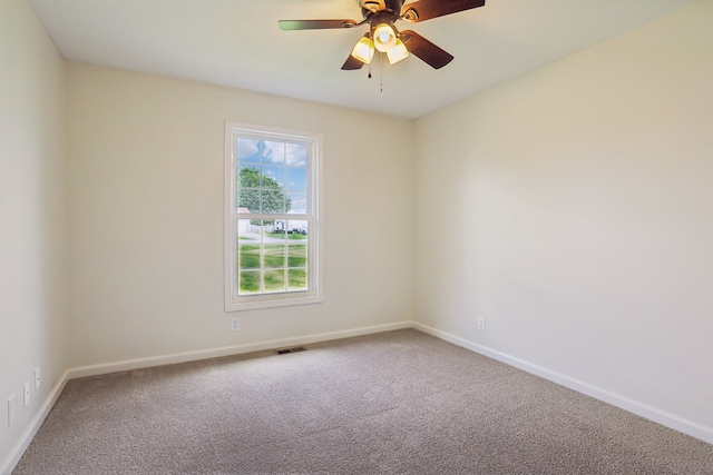 carpeted spare room with ceiling fan and plenty of natural light