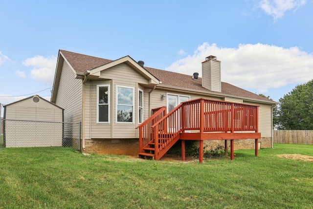 back of property featuring a lawn, a deck, and a shed