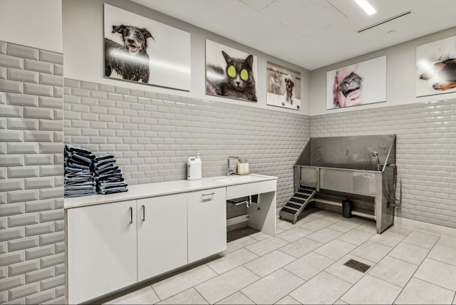 miscellaneous room with sink and light tile patterned floors