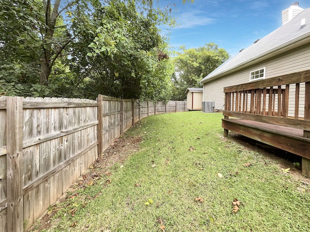 view of yard featuring cooling unit, a wooden deck, and an outdoor structure