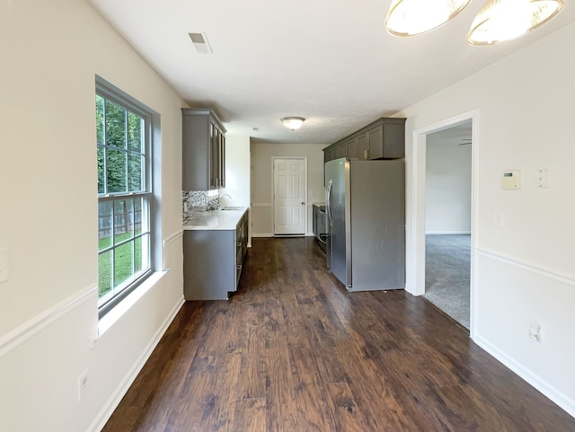 kitchen featuring a wealth of natural light, stainless steel refrigerator, sink, and dark hardwood / wood-style floors