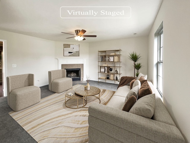 carpeted living room featuring ceiling fan and a fireplace