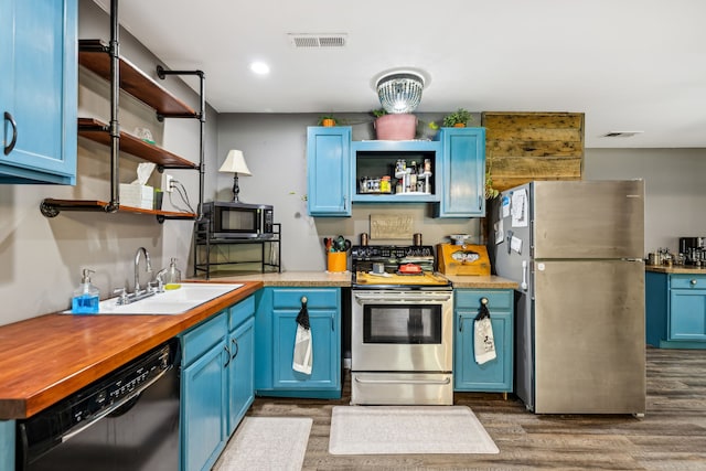 kitchen with sink, stainless steel appliances, blue cabinets, and wood-type flooring