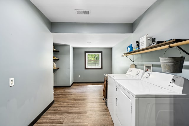 laundry area featuring washer and clothes dryer and wood-type flooring