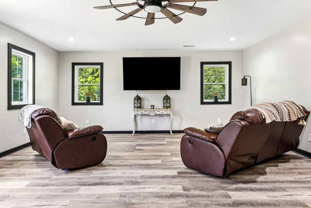 living room featuring hardwood / wood-style flooring, a healthy amount of sunlight, and ceiling fan