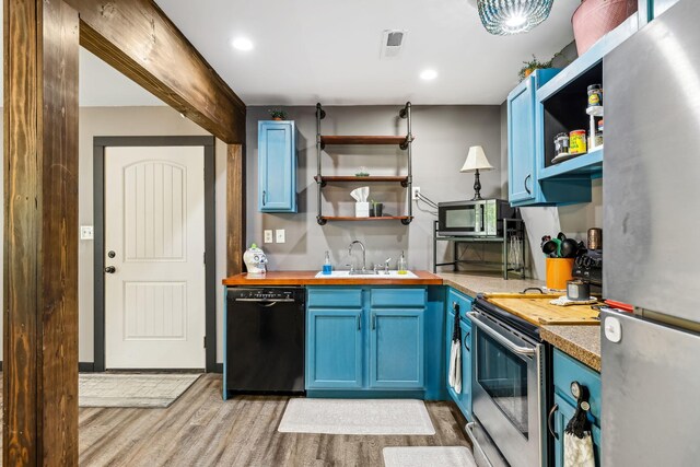 kitchen featuring light hardwood / wood-style floors, appliances with stainless steel finishes, sink, and blue cabinets