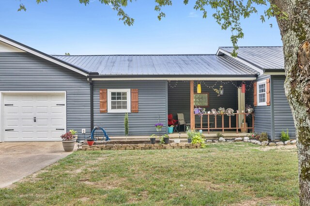 ranch-style house featuring a garage, a front yard, and covered porch