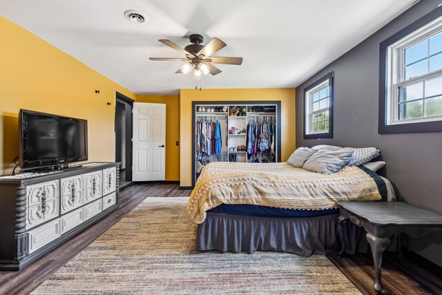 bedroom with ceiling fan, a closet, and dark wood-type flooring