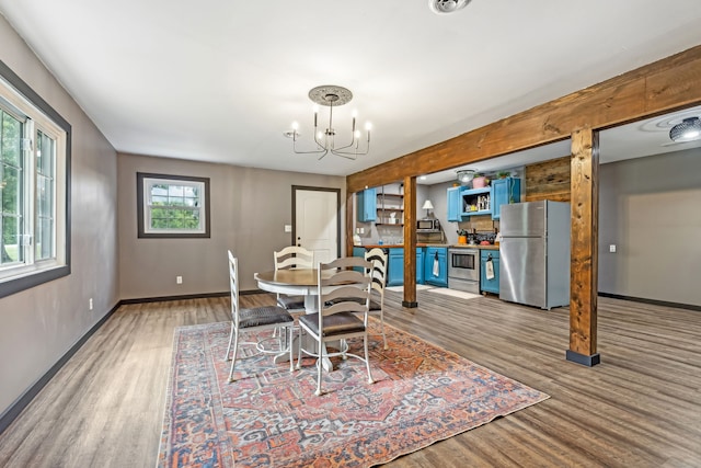 dining space featuring hardwood / wood-style floors and a chandelier