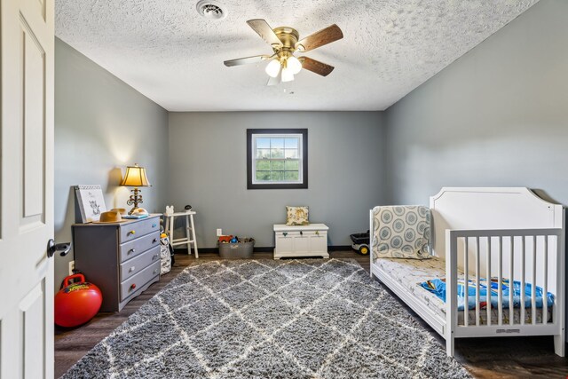 bedroom featuring ceiling fan, a textured ceiling, and dark hardwood / wood-style flooring