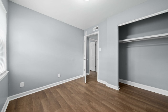 unfurnished bedroom featuring hardwood / wood-style flooring and a closet