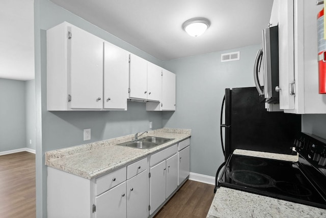 kitchen with white cabinetry, dark hardwood / wood-style floors, sink, black refrigerator, and stove