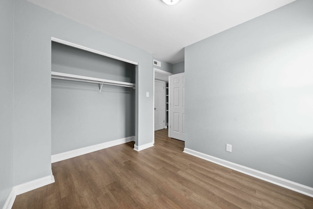 unfurnished bedroom with wood-type flooring and a closet