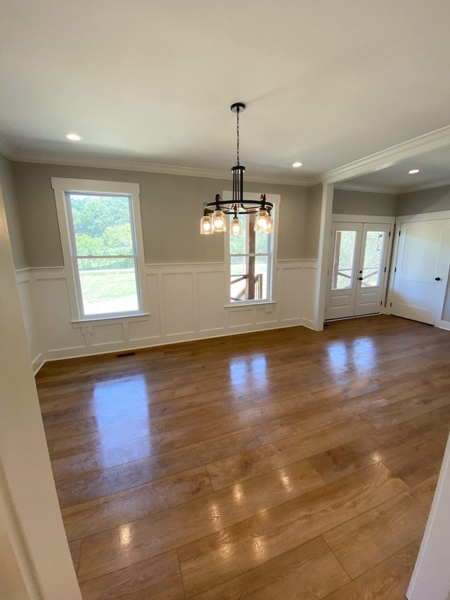 unfurnished dining area with a notable chandelier, recessed lighting, visible vents, ornamental molding, and wood finished floors