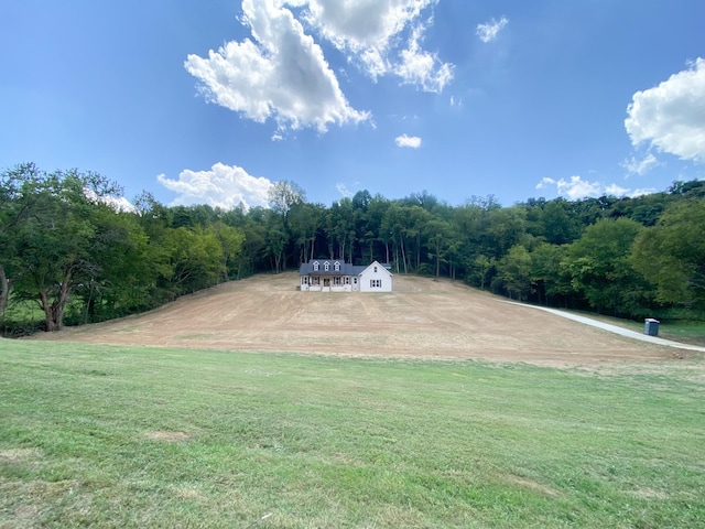 view of property's community with a wooded view and a lawn