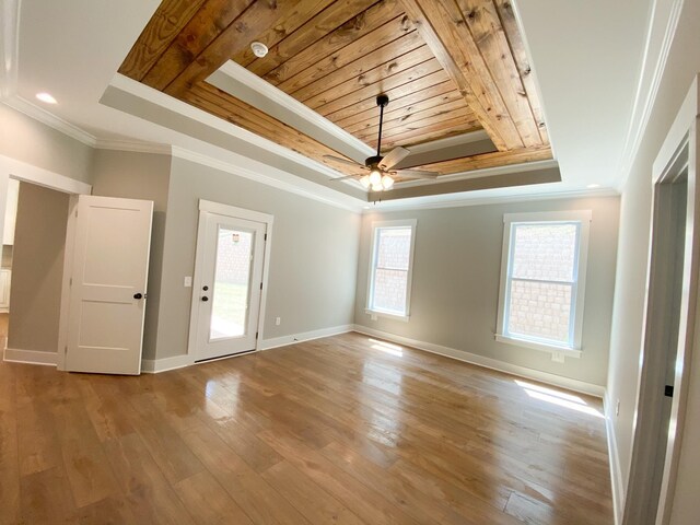 unfurnished room with a tray ceiling, wooden ceiling, a healthy amount of sunlight, and light wood-type flooring