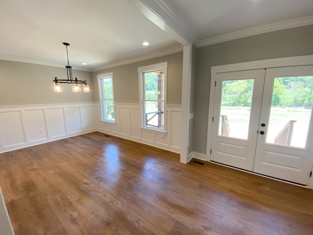 doorway with crown molding, wood-type flooring, french doors, and an inviting chandelier