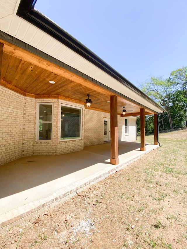 back of property with a patio area, ceiling fan, and brick siding