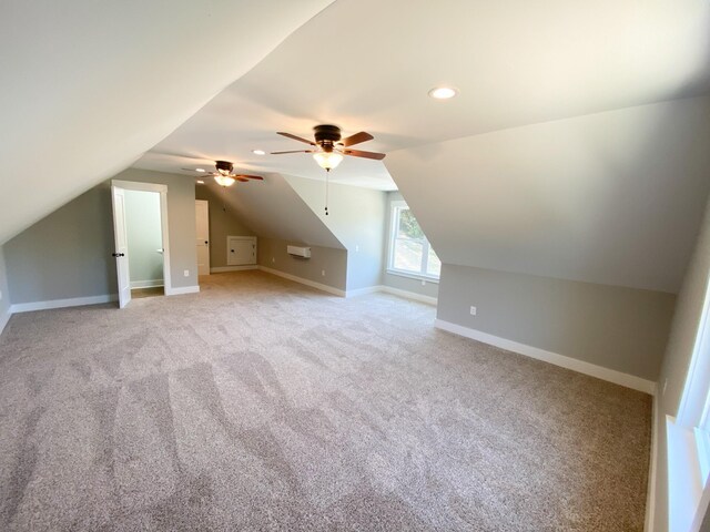 bonus room with vaulted ceiling, ceiling fan, and light colored carpet