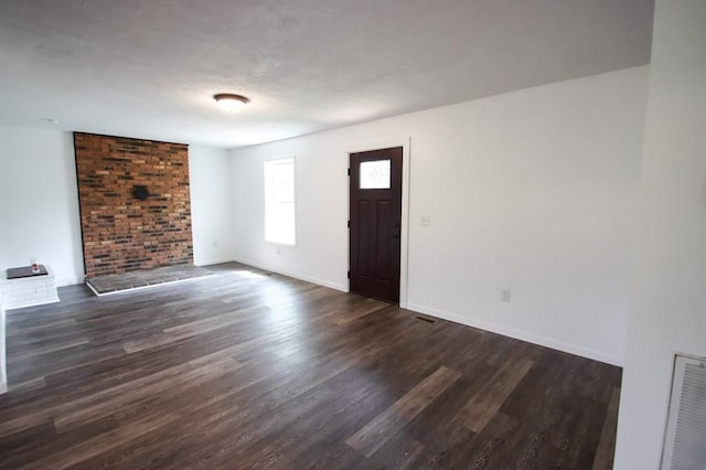 foyer featuring dark wood finished floors, visible vents, and baseboards