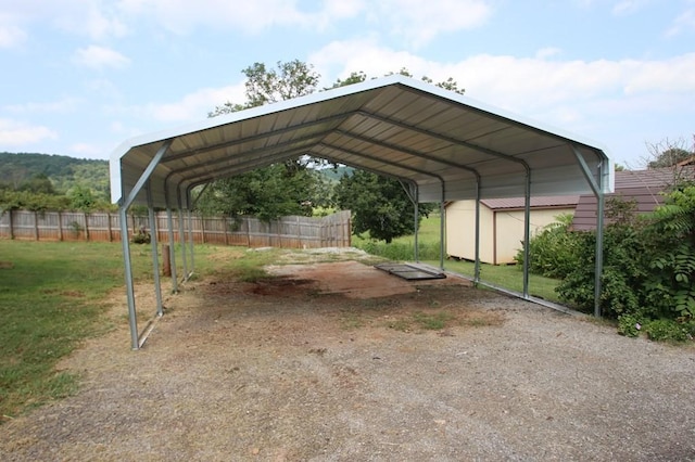 view of vehicle parking with a detached carport and fence