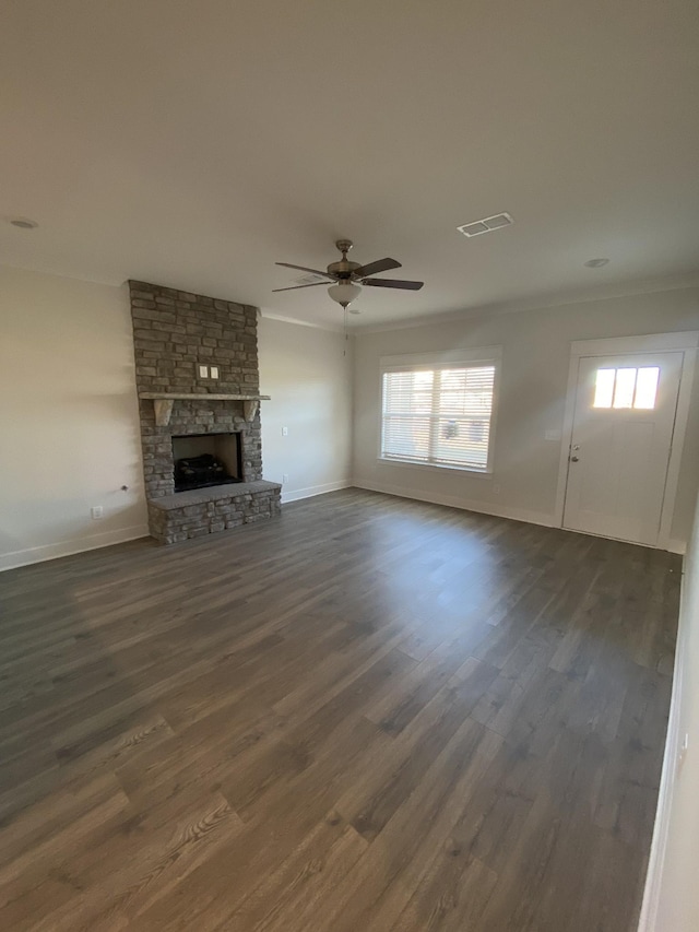 unfurnished living room featuring a fireplace, dark wood-type flooring, and a healthy amount of sunlight