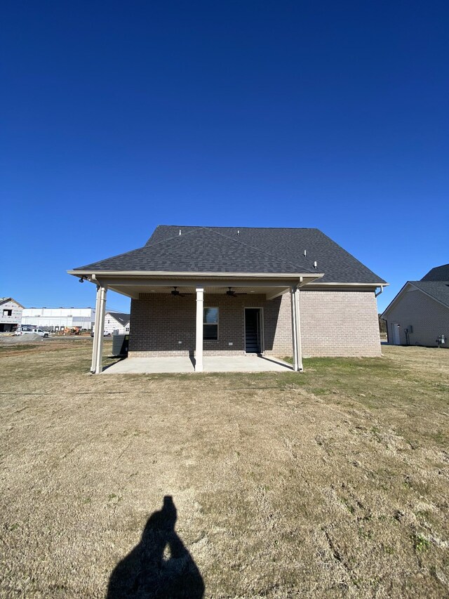 back of house featuring ceiling fan, a patio area, and a lawn