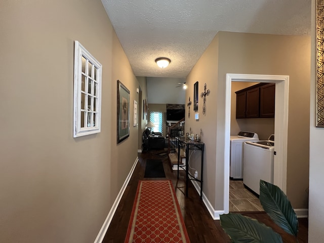 corridor with separate washer and dryer, hardwood / wood-style flooring, and a textured ceiling